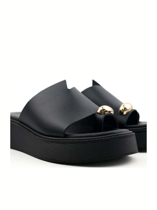 Schwarze Flatforms Goldenelement am Zeh
